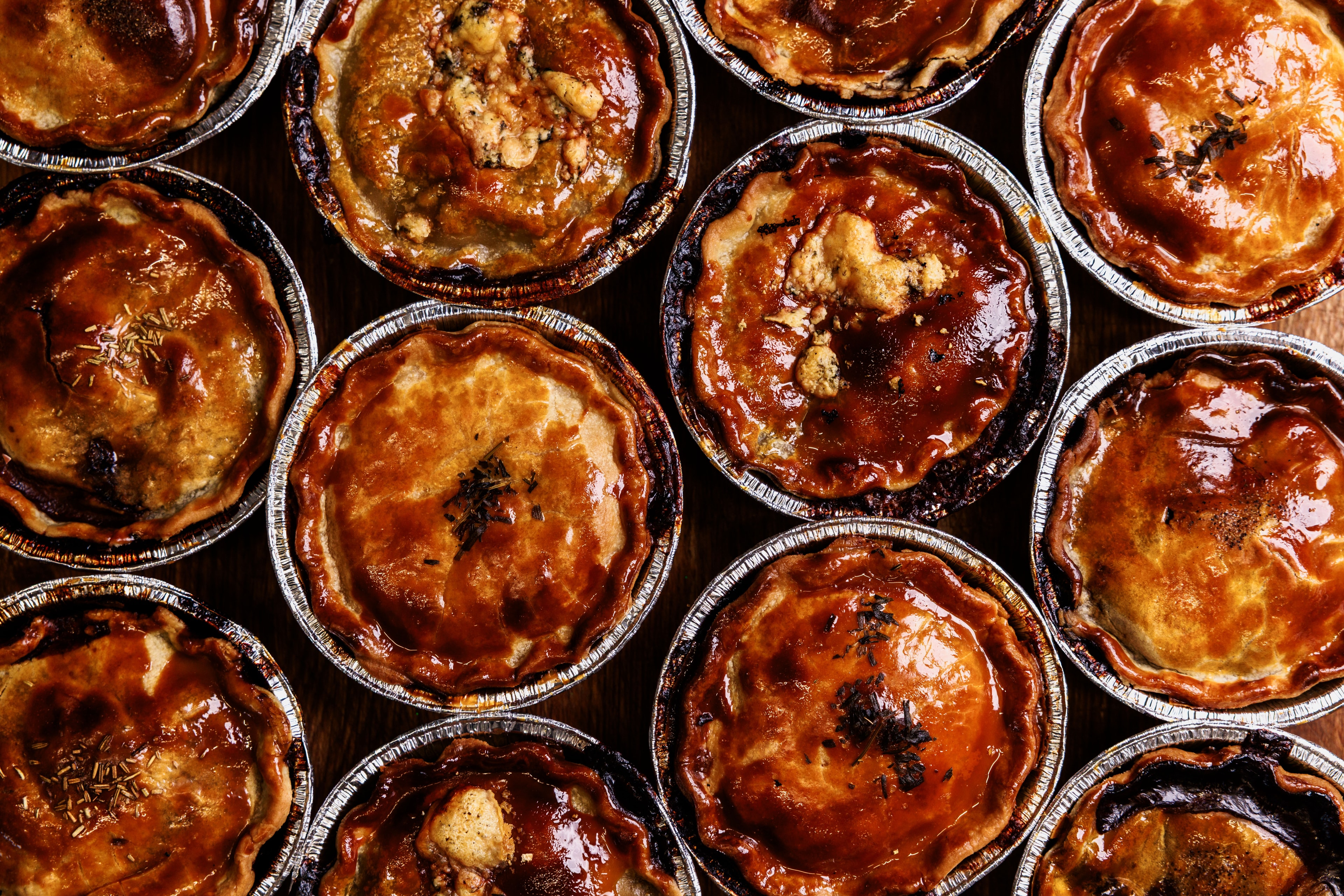 Freshly baked pies in foil tins, seen from above